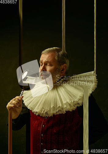 Image of Senior man as a medieval knight, duke on dark background, stylish creative design