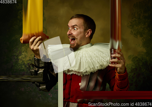 Image of Young man as a medieval knight on dark background, stylish creative design