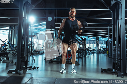 Image of The male athlete training hard in the gym. Fitness and healthy life concept.