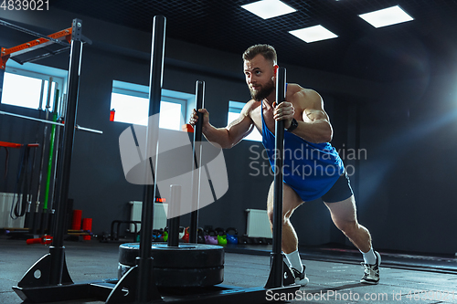 Image of The male athlete training hard in the gym. Fitness and healthy life concept.