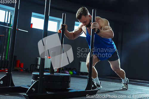 Image of The male athlete training hard in the gym. Fitness and healthy life concept.