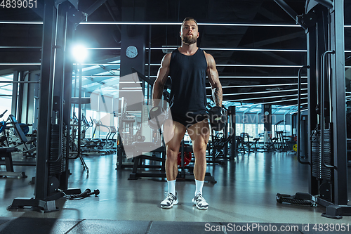 Image of The male athlete training hard in the gym. Fitness and healthy life concept.