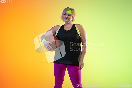 Image of Young caucasian plus size female model\'s training on gradient orange background