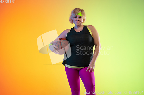 Image of Young caucasian plus size female model\'s training on gradient orange background