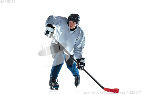 Image of Young male hockey player with the stick on ice court and white background