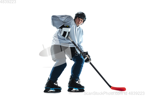 Image of Young male hockey player with the stick on ice court and white background