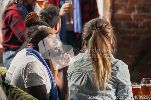 Image of Excited group of people watching football, sport match at home