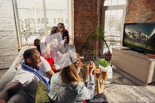 Image of Excited group of people watching sport match at home