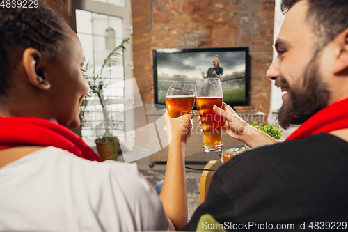 Image of Excited group of people watching sport match at home