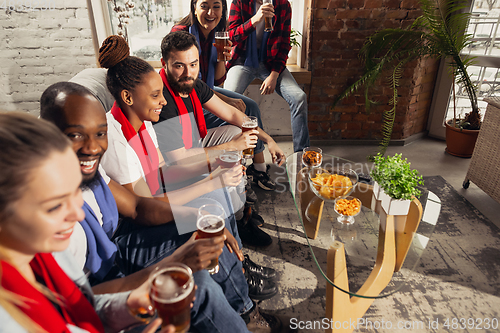 Image of Excited group of people watching football, sport match at home