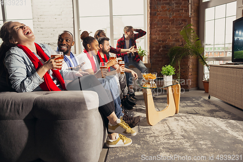 Image of Excited group of people watching sport match at home