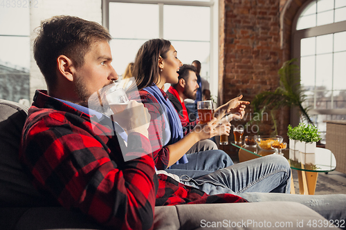 Image of Excited group of people watching football, sport match at home