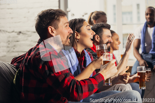 Image of Excited group of people watching football, sport match at home