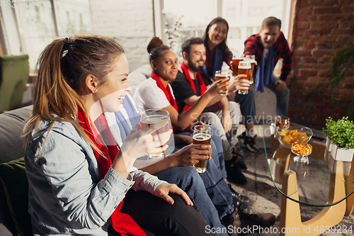 Image of Excited group of people watching football, sport match at home
