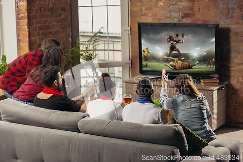 Image of Excited group of people watching sport match at home