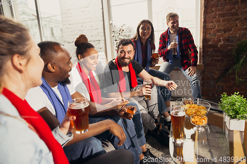Image of Excited group of people watching football, sport match at home