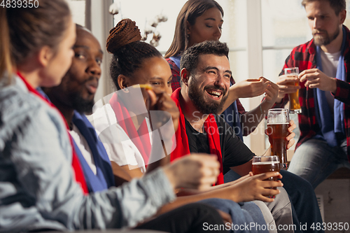 Image of Excited group of people watching football, sport match at home
