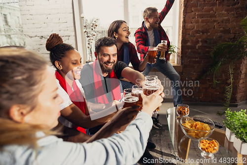 Image of Excited group of people watching football, sport match at home
