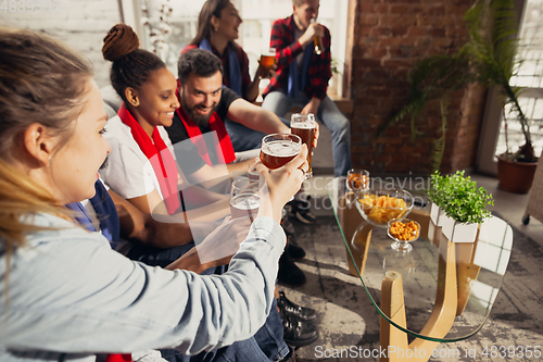 Image of Excited group of people watching football, sport match at home