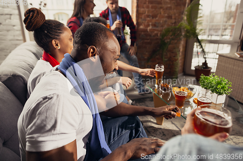 Image of Excited group of people watching football, sport match at home