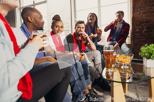 Image of Excited group of people watching football, sport match at home