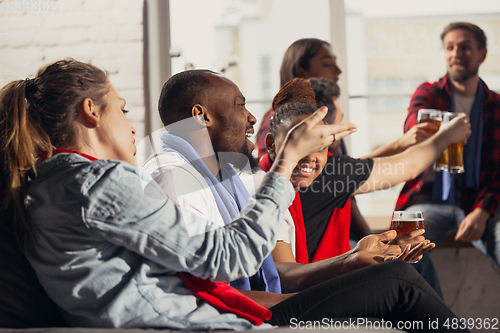 Image of Excited group of people watching football, sport match at home