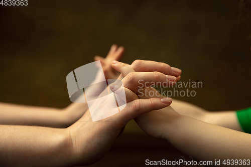 Image of Close up of female and kid\'s hands doing things together, family, home concept