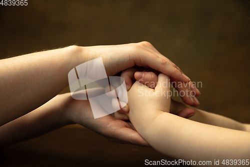 Image of Close up of female and kid\'s hands doing things together, family, home concept