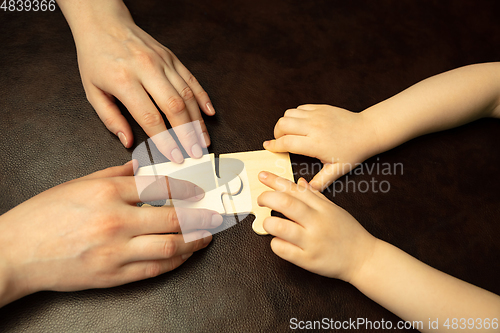 Image of Close up of female and kid\'s hands doing things together, family, home concept