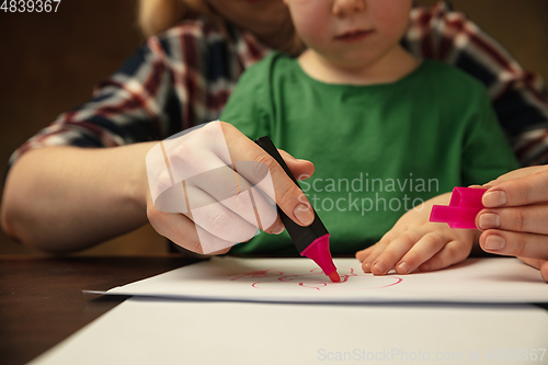 Image of Close up of female and kid\'s hands doing things together, family, home concept