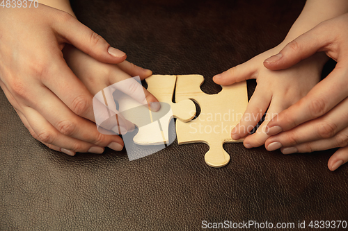 Image of Close up of female and kid\'s hands doing things together, family, home concept