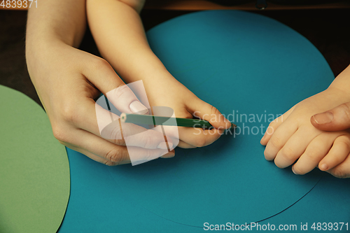 Image of Close up of female and kid\'s hands doing things together, family, home concept