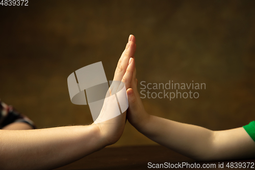 Image of Close up of female and kid\'s hands doing things together, family, home concept