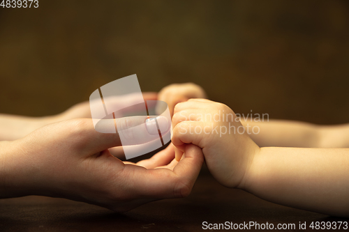 Image of Close up of female and kid\'s hands doing things together, family, home concept