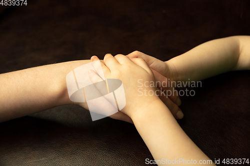 Image of Close up of female and kid\'s hands doing things together, family, home concept