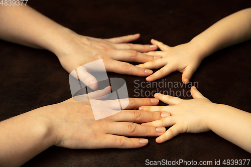 Image of Close up of female and kid\'s hands doing things together, family, home concept