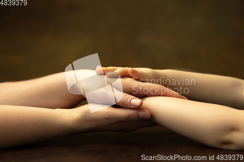 Image of Close up of female and kid\'s hands doing things together, family, home concept