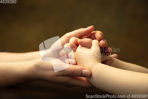 Image of Close up of female and kid\'s hands doing things together, family, home concept