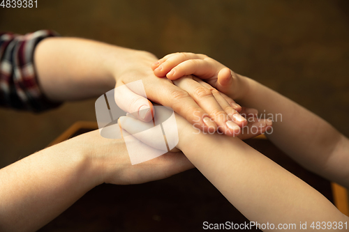 Image of Close up of female and kid\'s hands doing things together, family, home concept