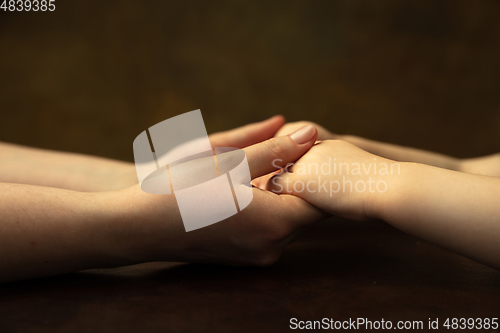 Image of Close up of female and kid\'s hands doing things together, family, home concept