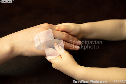 Image of Close up of female and kid\'s hands doing things together, family, home concept