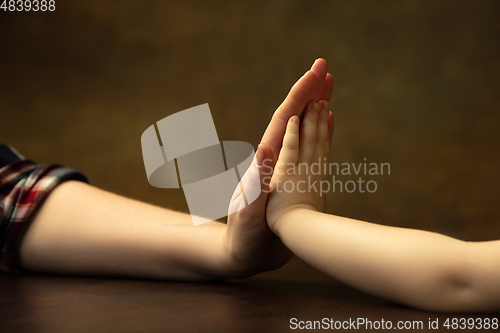 Image of Close up of female and kid\'s hands doing things together, family, home concept