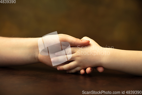 Image of Close up of female and kid\'s hands doing things together, family, home concept