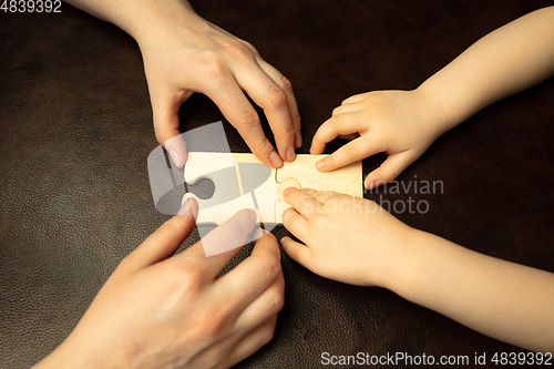 Image of Close up of female and kid\'s hands doing things together, family, home concept