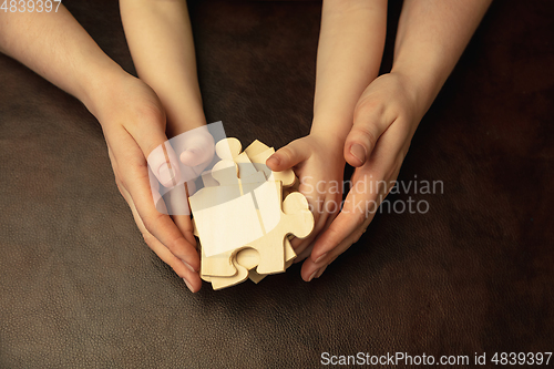 Image of Close up of female and kid\'s hands doing things together, family, home concept