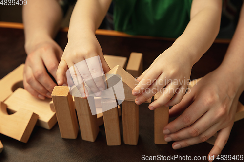 Image of Close up of female and kid\'s hands doing things together, family, home concept