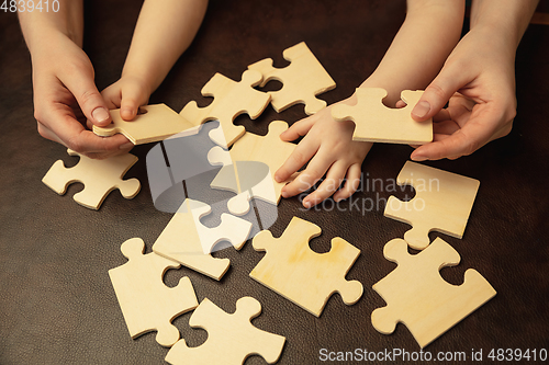 Image of Close up of female and kid\'s hands doing things together, family, home concept
