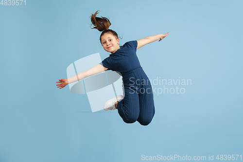 Image of Pretty caucasian girl portrait isolated on blue studio background with copyspace