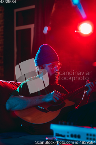 Image of Close-up of musician performing in neon light. Concept of advertising, hobby, music, festival, entertainment.