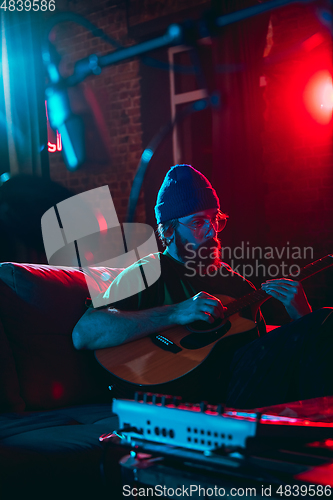 Image of Close-up of musician performing in neon light. Concept of advertising, hobby, music, festival, entertainment.